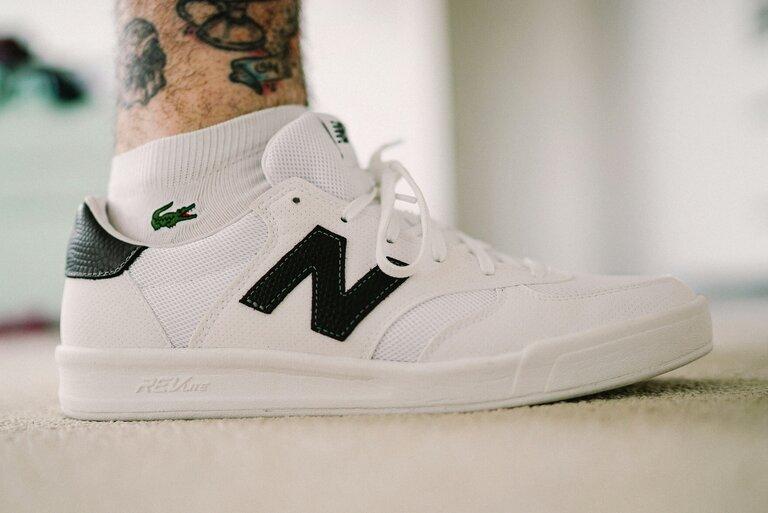 Weißer New Balance Sneaker auf braunem Textil
