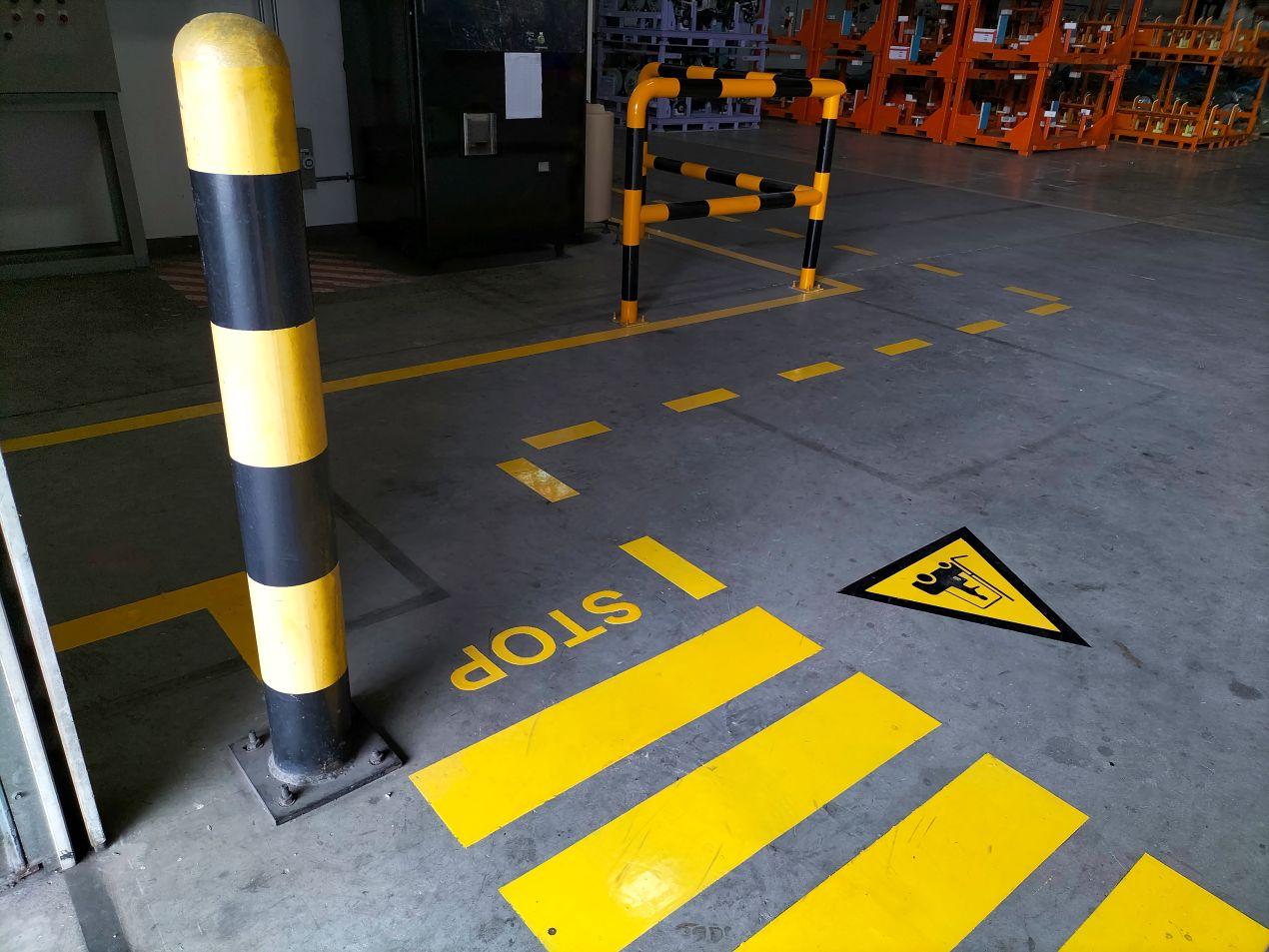 Innenbereich mit Bodenmarkierung, Stop-Zeichen und Sicherheitsabgrenzung