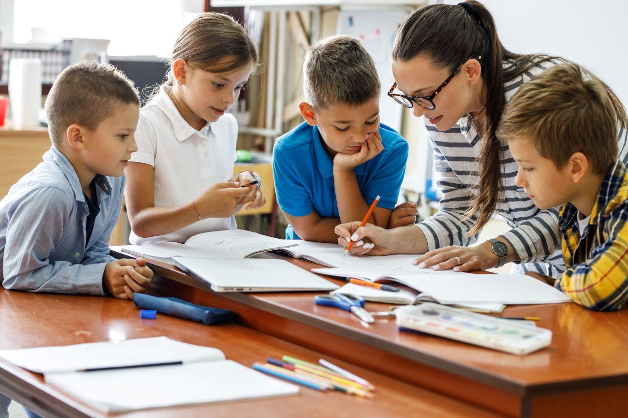 Lehrerin mit Schuelern im Klassenzimmer – gemeinsames Lernen und kosten privatschule berlin im Fokus