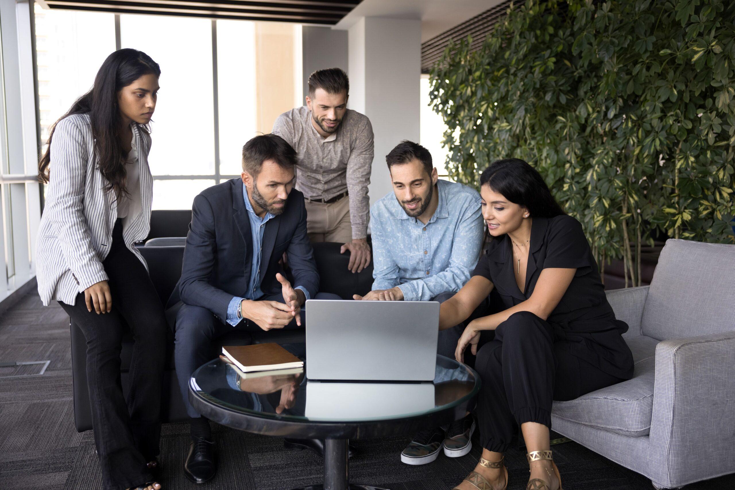 Fokussiertes Team bei gemeinsamer Laptop-Arbeit in modernem Büro