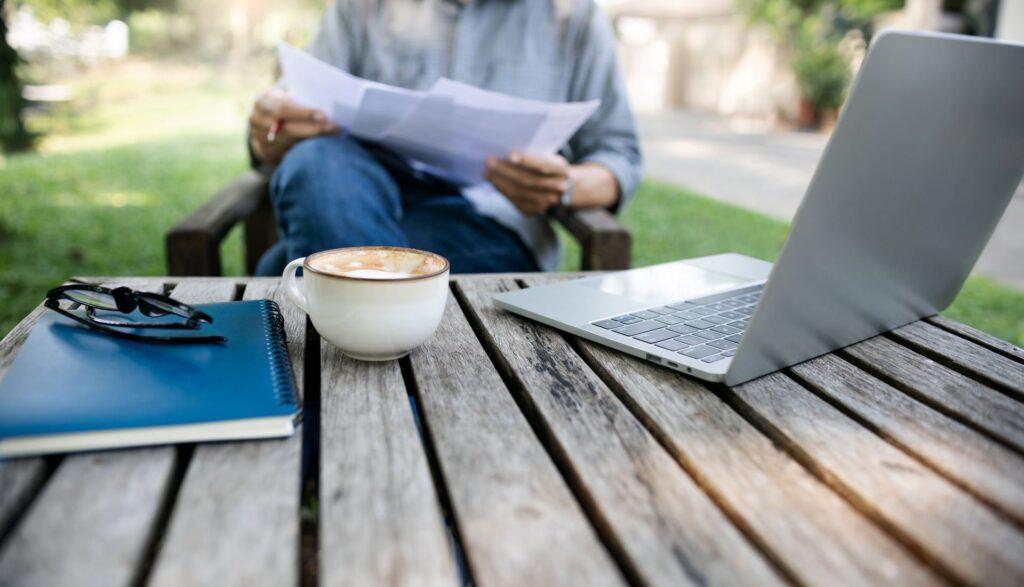 Laptop und Kaffee im Garten mit Aussenküche