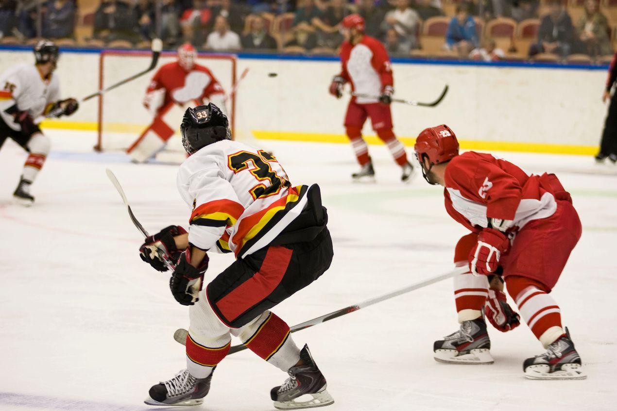 Eishockeyspieler mit Schlittschuhe Bauer im Spiel gegen rote Mannschaft