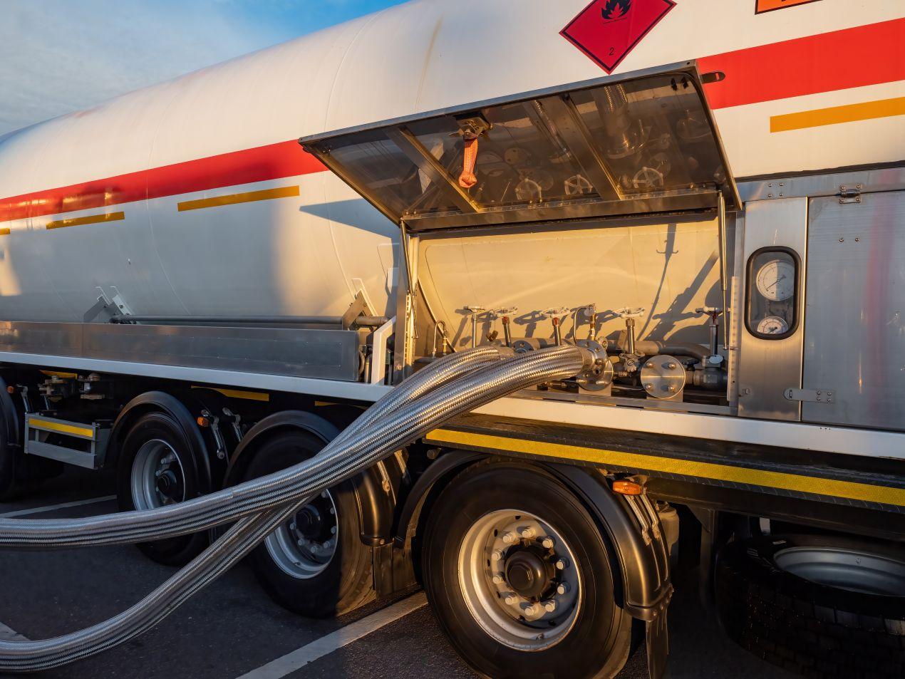 Metallische Förderschläuche verbinden ein Gefahrgut-Tankfahrzeug mit einer Industrieanlage für sichere Medienübertragung