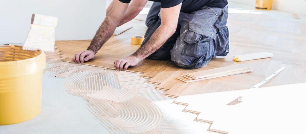 Handwerker verlegt Holzboden – was Raumklima mit Klick Vinyl kaufen zu tun hat