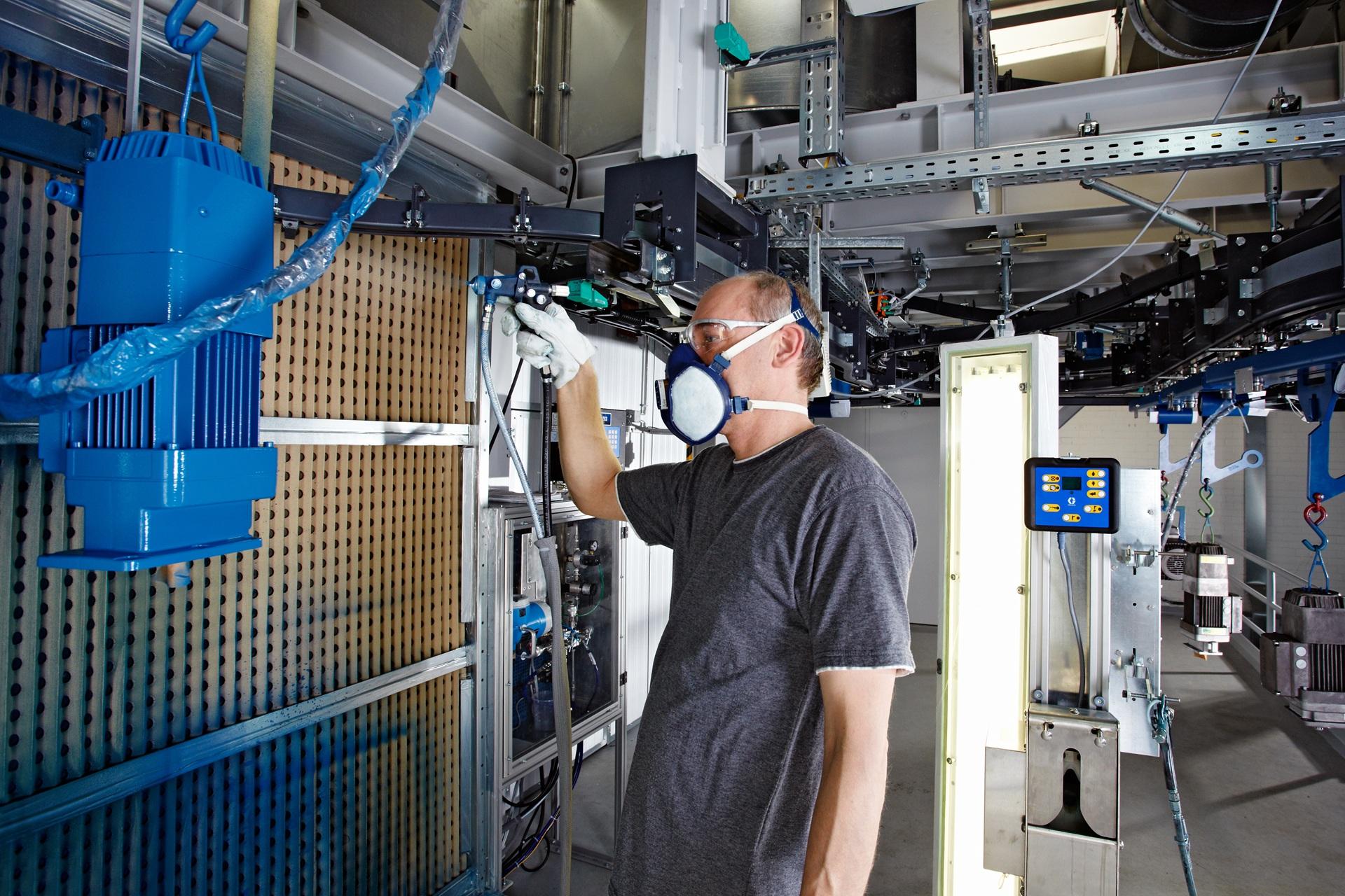 Arbeiter lackiert Bauteil mit Atemschutzmaske | Industriesauger Staub