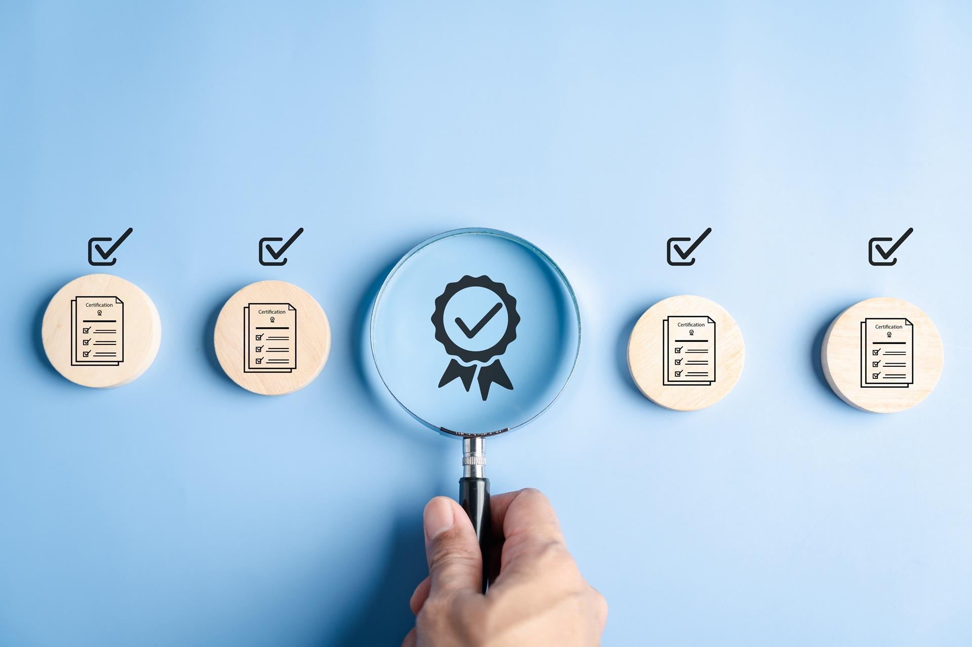 Lupe zeigt Qualitätssymbol zwischen Zertifizierungsicons | Vorrichtungsbau